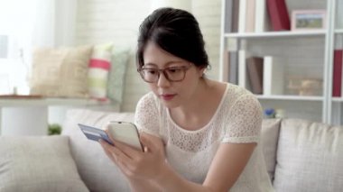 Asyalı kadın onun online alışveriş bitirmek için onun kredi kartı şifresini tuşlayarak yavaş hareket.