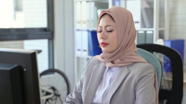 Ofiste çalışan onun masasında oturan genç kadın portresi.