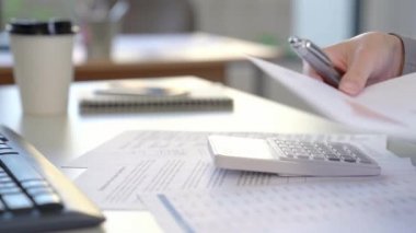 Hesap makinesi ve ofiste masa üzerinde finansal verileri analiz kullanarak işkadını'nın elleri