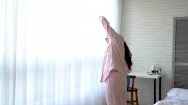 Yatak odasında sabahın erken saatlerinde egzersiz yaparak sağlıklı Asyalı kadın. O ısınma ve bugün yüz göreve hazırlanıyor.