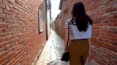 Konut antik yolda yürürken Asyalı kadın hızlı hareket alanı ve o döndü kameraya bakmak için.