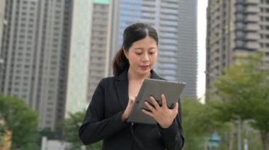 Arazi fiyat kontrol için dijital tablet kullanarak genç iş kadını çevreliyor şehir kurma.