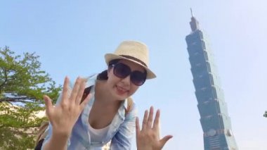 Asyalı Genç kızın ellerini sallayarak ve Taipei 101 bir dahaki sefere gelmek için arkadaşları davet ağır çekim.