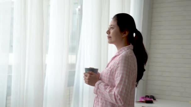 Mulher Asiática Segurando Uma Caneca Lado Janela Para Observar Tempo — Vídeo de Stock