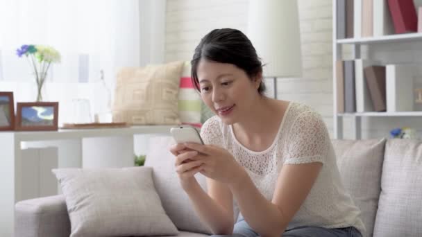Asiática Mujer Sentada Sofá Mensajes Texto Con Sus Amigos Para — Vídeo de stock