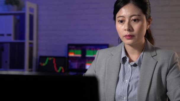 アジア証券アナリスト研究 近代的なオフィスの最新のグラフです アジア女性が夜働いて新しい金融ニュースをキャッチします — ストック動画