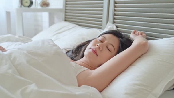 时尚亚洲女士早上醒来 伸出双臂 以获得更多的能量 她看起来舒适舒适的床上 — 图库视频影像