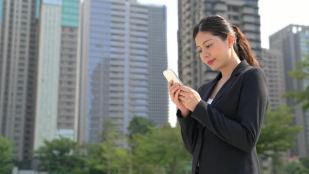 クライアント携帯電話で魅力的なアジアの若い実業家テキスト メッセージ — ストック動画