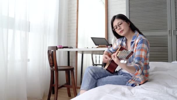 Mujer Asiática Joven Tocando Guitarra Cama Ella Disfruta Tiempo Libre — Vídeo de stock