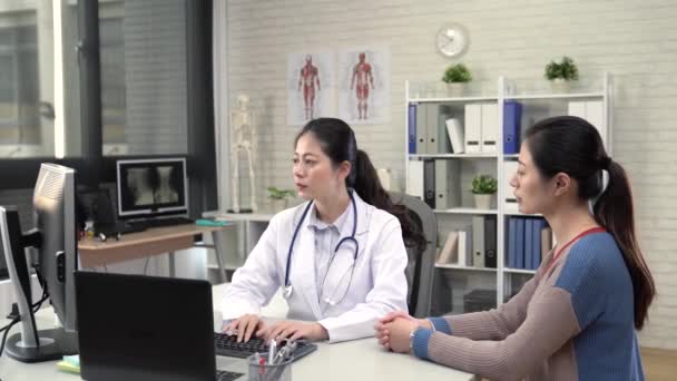 Asiática Mujer Médico Escribiendo Abajo Los Síntomas Chica — Vídeo de stock