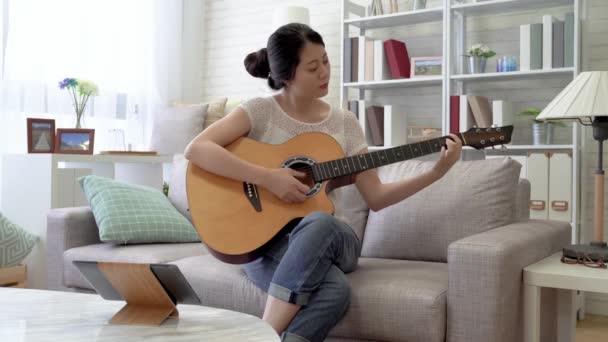 Musicienne Asiatique Jouant Guitare Lisant Les Notes Sur Pad Numérique — Video