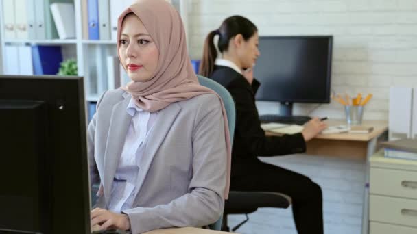 专业的穆斯林妇女在计算机上工作 而她的同事在电话上通话的背景 启动业务团队合作理念 — 图库视频影像