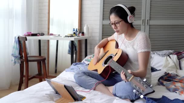 アジア女性ミュージシャンが彼女自身によって彼女の新しいアルバムのレコーディングします 彼女は身に着けているヘッドフォンとデジタル タブレットを使用します 彼女はビートを次に集中してください — ストック動画