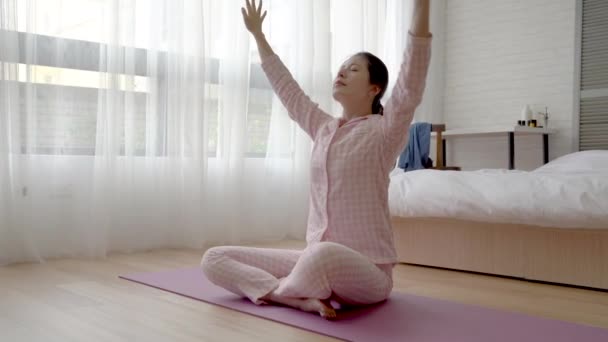 Asiatische Frau Sitzt Auf Der Yogamatte Und Zieht Dann Einen — Stockvideo