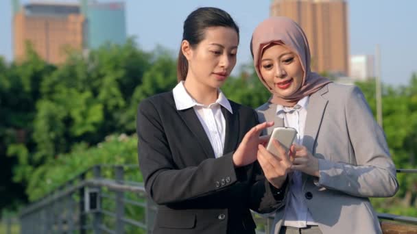 Азиатская Женщина Показывает Мобильный Смартфон Своему Коллеге Разговаривает Пределами Офиса — стоковое видео
