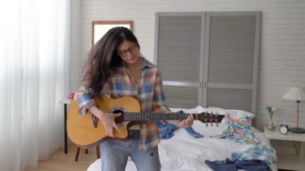 アジアの女性は 簡単なモードでギターを弾いています 彼女はスイングし — ストック動画