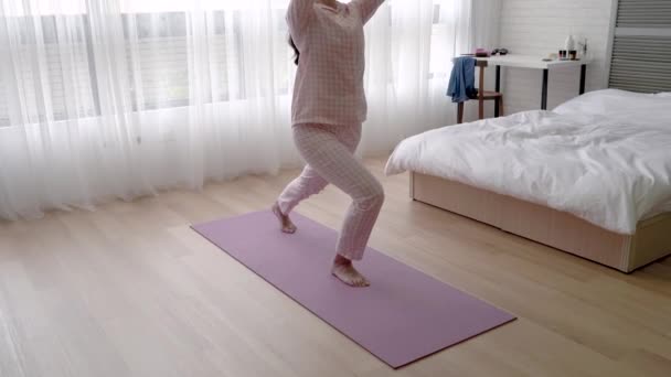 アジア女性ゆっくり弓姿勢をしていると 彼女の手を上げる — ストック動画
