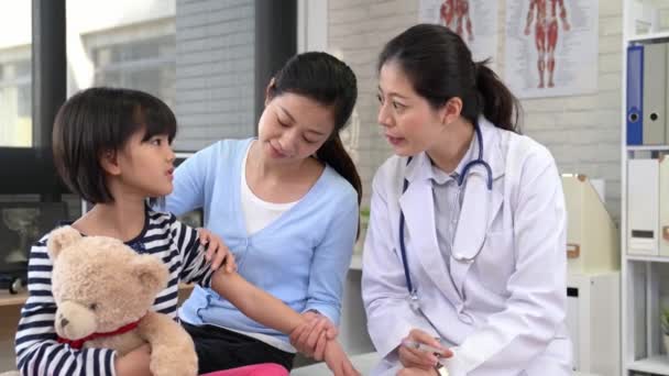 亚洲医生帮助小病人注射 孩子们耐心深呼吸 拿着玩具熊玩具 — 图库视频影像