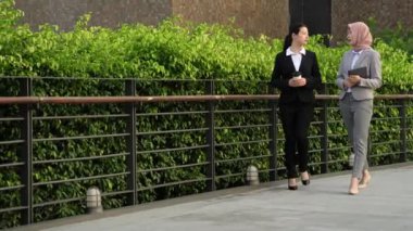 yürümeye ve konuşmaya, açık iki genç Asya ve Müslüman iş kadınları. iş mobil ofis kavramı.