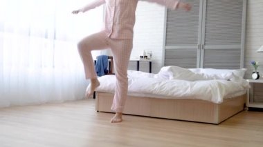 Asyalı kadın onu egzersiz yapıyor ve onun nefes kontrol odaklanarak. O bacaklarını yükseltir ve yenilgiler ve müzik takip kollarını salıncak.