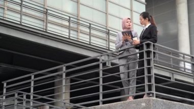 Dijital tablet Emlak Müslüman Yöneticisi'ni kullanarak ofis binası dışında ayakta onun şirketinin işlerine bakıyoruz için piyasada açıklamak.