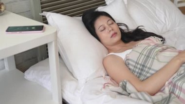Genç modern smartphone alarmı duydunuz ve uyandım ama o kapatmak değil. Uğultu tutmak bırak.