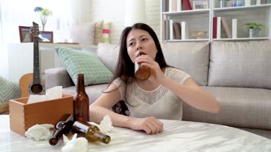 ağır çekim Asyalı kadın gitar Yarışması kaybettim. O sarhoş kendini onun stres serbest bırakmak için bira içti.