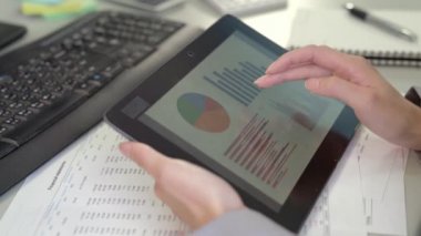 Eller multitasking kadın tablet, dizüstü bilgisayar ve wifi bağlama ve Pazar grafik arıyorum cep telefonu kullanarak, ileri sarma.