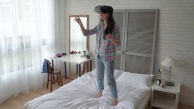 Bir kadın onun yatak ve Vr video oyunları oynarken durumda. O ellerini kaldır o gerçekten touch video oyununda sanal şeyler düşünce.