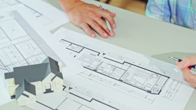 üst masada planı ile tartışırken mimar mühendis görünümünü yukarıda. Elleri ve proje yazdırma üzerinde Kapat