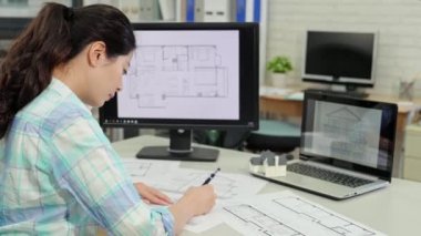 Dikiz outlook tasarım kontrol etmek için kadın mimar kroki çizim ve bir ev örnek model tutan bilgisayar ile çalışma.