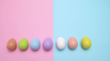 Masaya koy Paskalya yumurtaları tek tek yok oluyor. Bir punchy pastel arka plan üzerinde.
