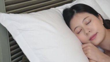 Yorucu kız derin yumuşak yatakta uyur. O görünüyor tadını çıkarın ve rahat.