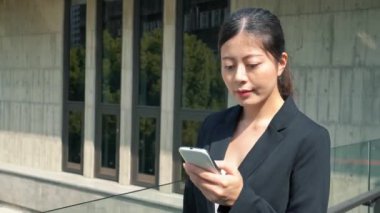 Patronu dostça bir gülümsemeyle açık havada yürüyüş siyah takım elbiseli çekici kadın manifatura mesaj.