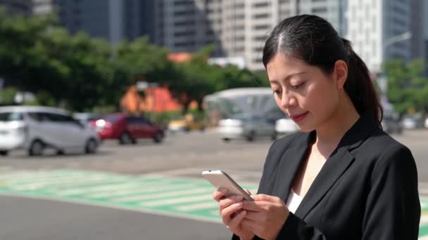 背景に車が通過する間にスマート フォン携帯メール メッセージを使用して ビジネスの女性 — ストック動画