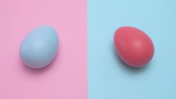 Dois Ovos Páscoa Respectivamente Vermelho Azul Girando Sobre Fundo Pastel — Vídeo de Stock