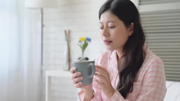 年轻的亚洲女士从床上醒来 喝了一杯咖啡以保持清醒 — 图库视频影像