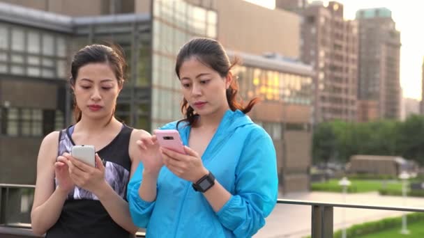 Two Young Women Jogger Take Break Using Smartphone Texting Message — Stock Video