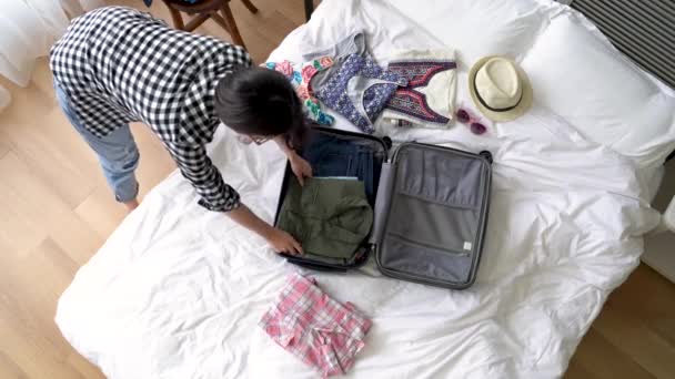 女の子は ちゃんとスーツケースに彼女の服を置きます 彼女は海外に行く — ストック動画