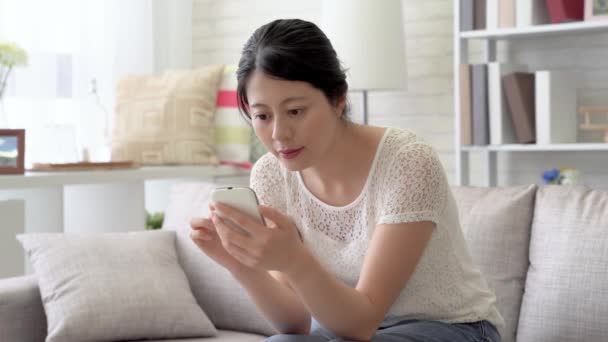 Asiatische Frau Die Wohnzimmer Sitzt Und Mit Ihrem Handy Sms — Stockvideo