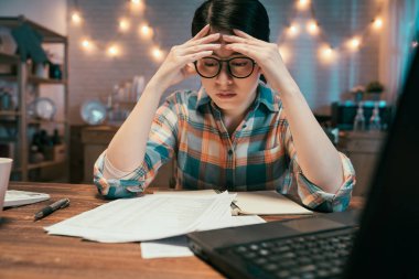 Karanlık mutfakta oturan kız çözümü düşünüyor.