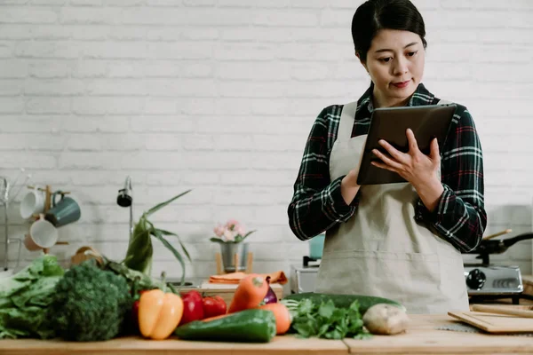Mujer usando la tableta en la cocina para la receta — Foto de Stock