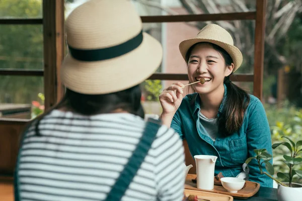 Lady in straw hat eating plum snack and laughing — Stock Photo, Image
