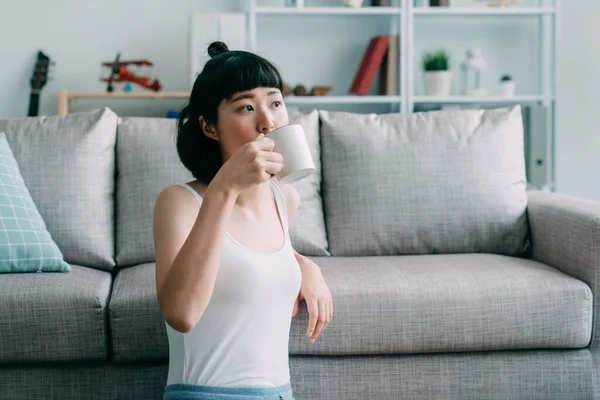 Schattig meisje kijken opzij drinken kopje thee — Stockfoto