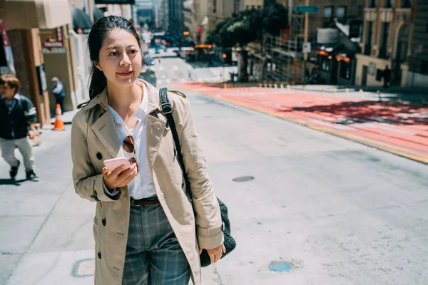 Mujer usando su teléfono móvil caminando — Foto de Stock