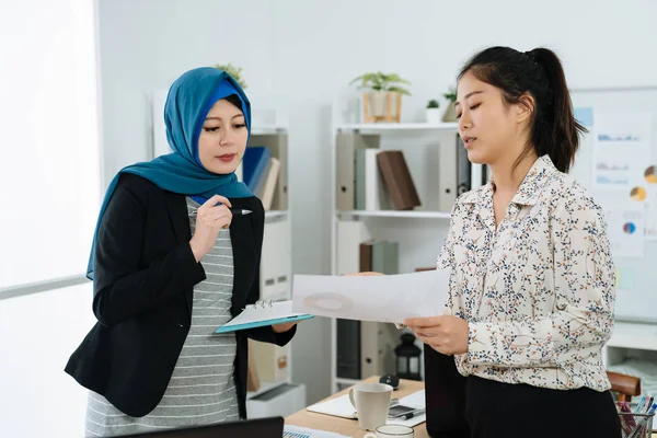 Maternity lady having discussion with coworker Stock Photo