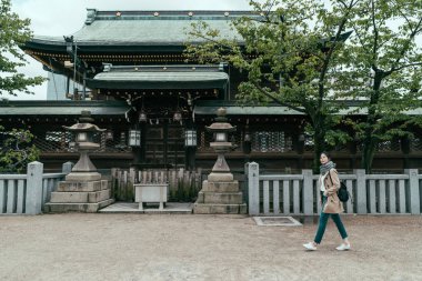 Sırt çantalı kız Osaka Tenmangu Tapınağında yürüyor