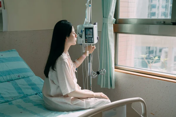 Loneliness sick woman on bed in hospital room Stock Image