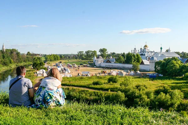 Homme et femme regardent le monastère d'intercession de la rive de la rivière Kamenka, Russie, Suzdal — Photo