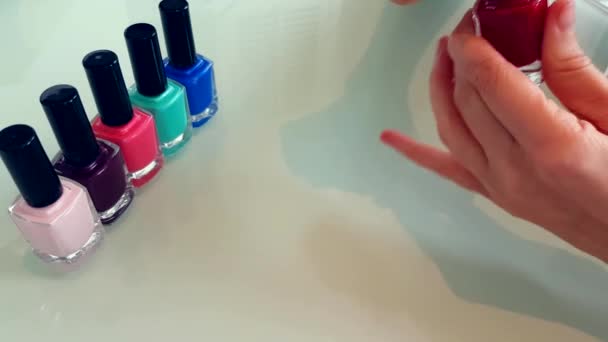 Жінка наносить червоний лак для нігтів — стокове відео